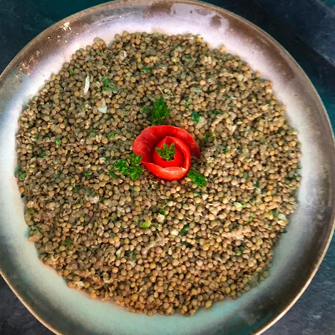 Assiette contenant des lentilles et une tomate au centre
